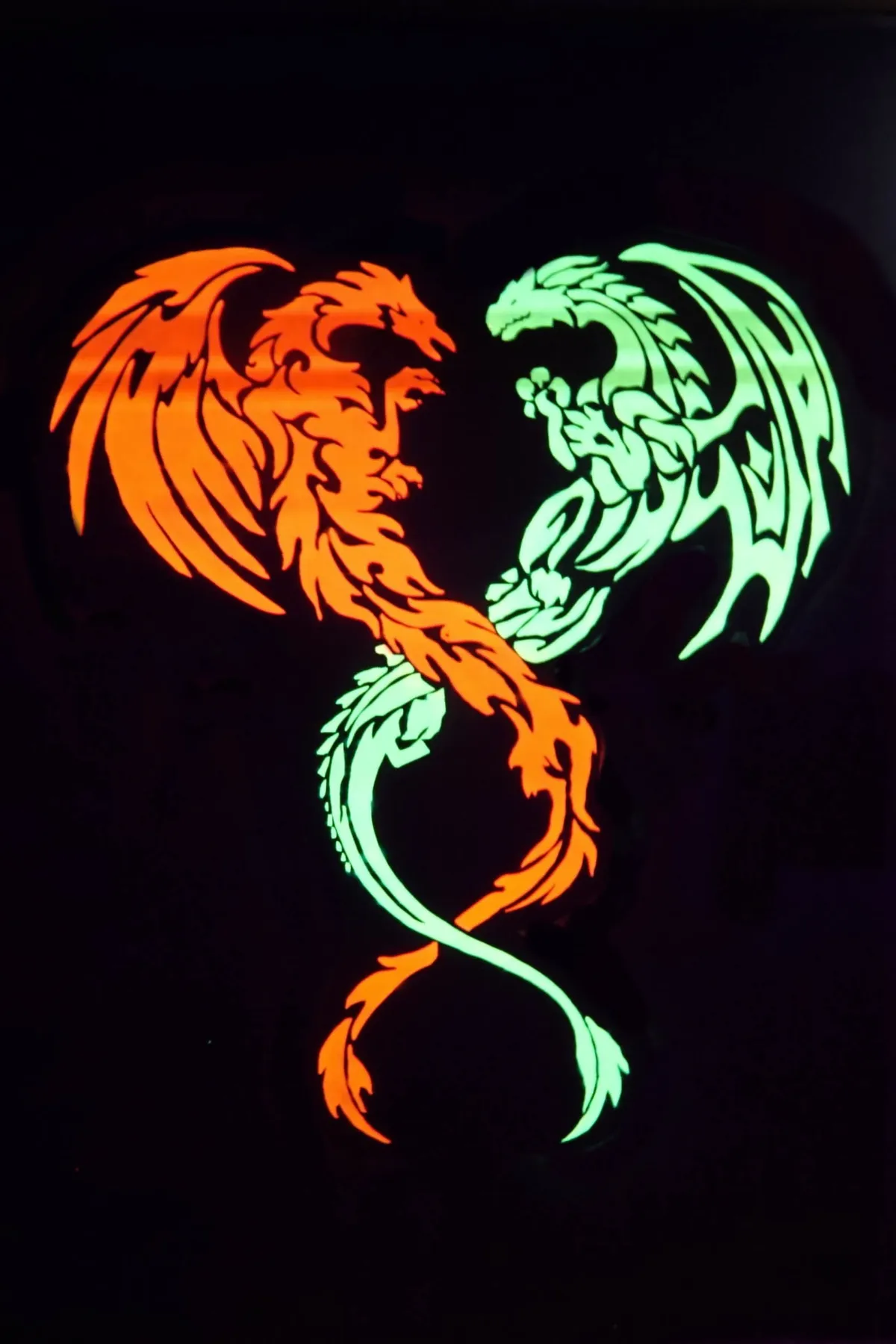 Zwei leuchtende Drachen in Orange und Grün auf schwarzem Hintergrund