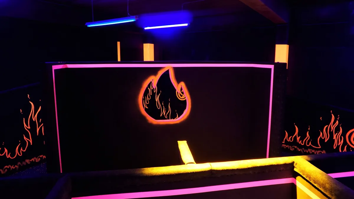 Dunkler Arenabereich mit neonbeleuchteten Flammenmotiven