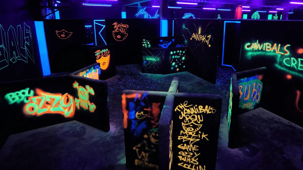 Labyrinth aus schwarzen Wänden mit leuchtenden Neon-Graffiti