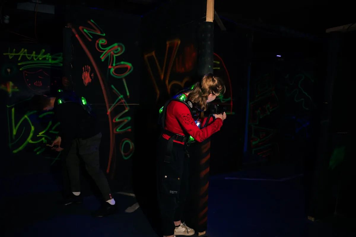 Zwei Spieler in der Arena vor leuchtenden Neon-Graffiti