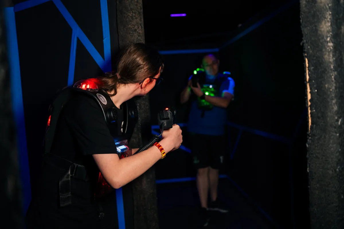 Spieler zielt mit dem Phaser in der dunklen Lasertag-Arena