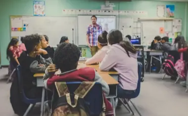Lehrer unterrichtet eine Klasse vor einer Tafel